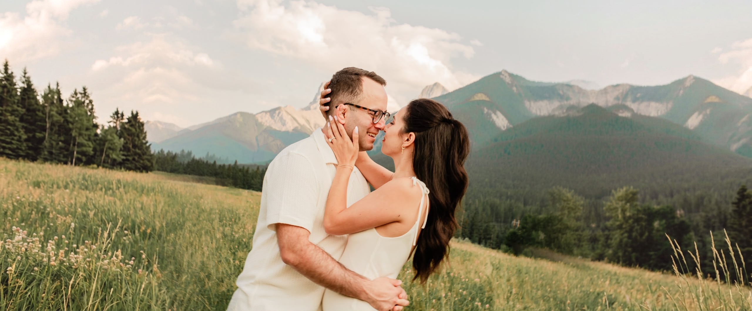 Nathalie and David embracing in a mountain meadow at sunset